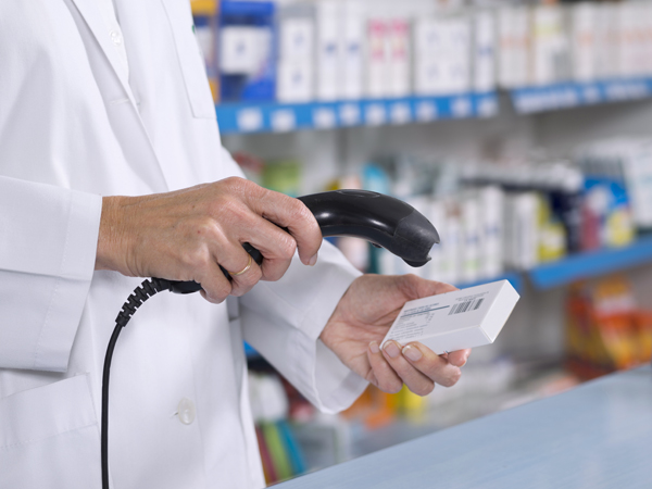Pharmacist scanning drugs at check-out counter