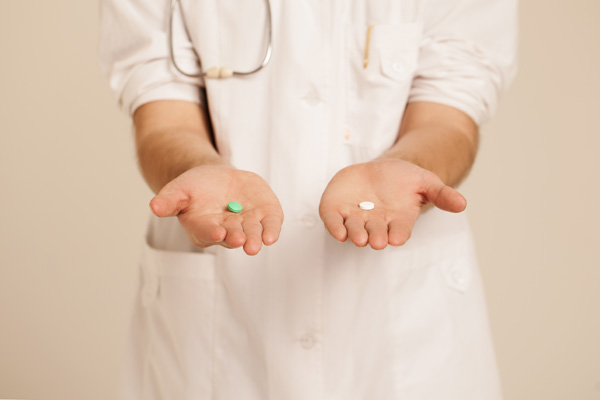 Doctor holding out two pills in hand
