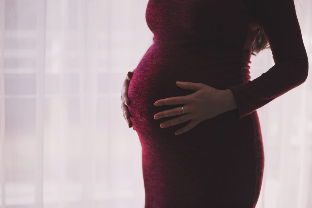 Pregnant woman holding belly