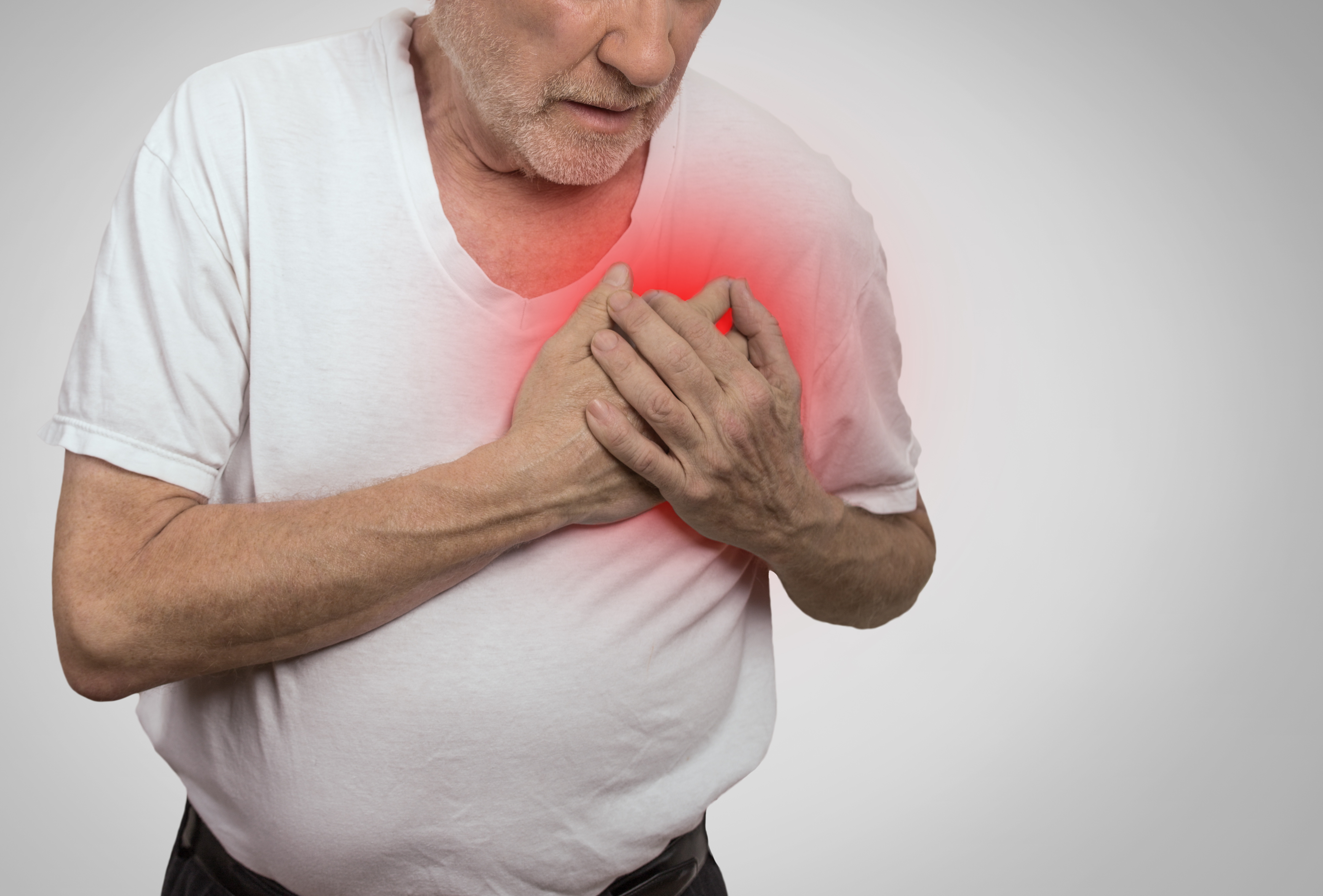 Man clutching his heart as a sign of heart attack