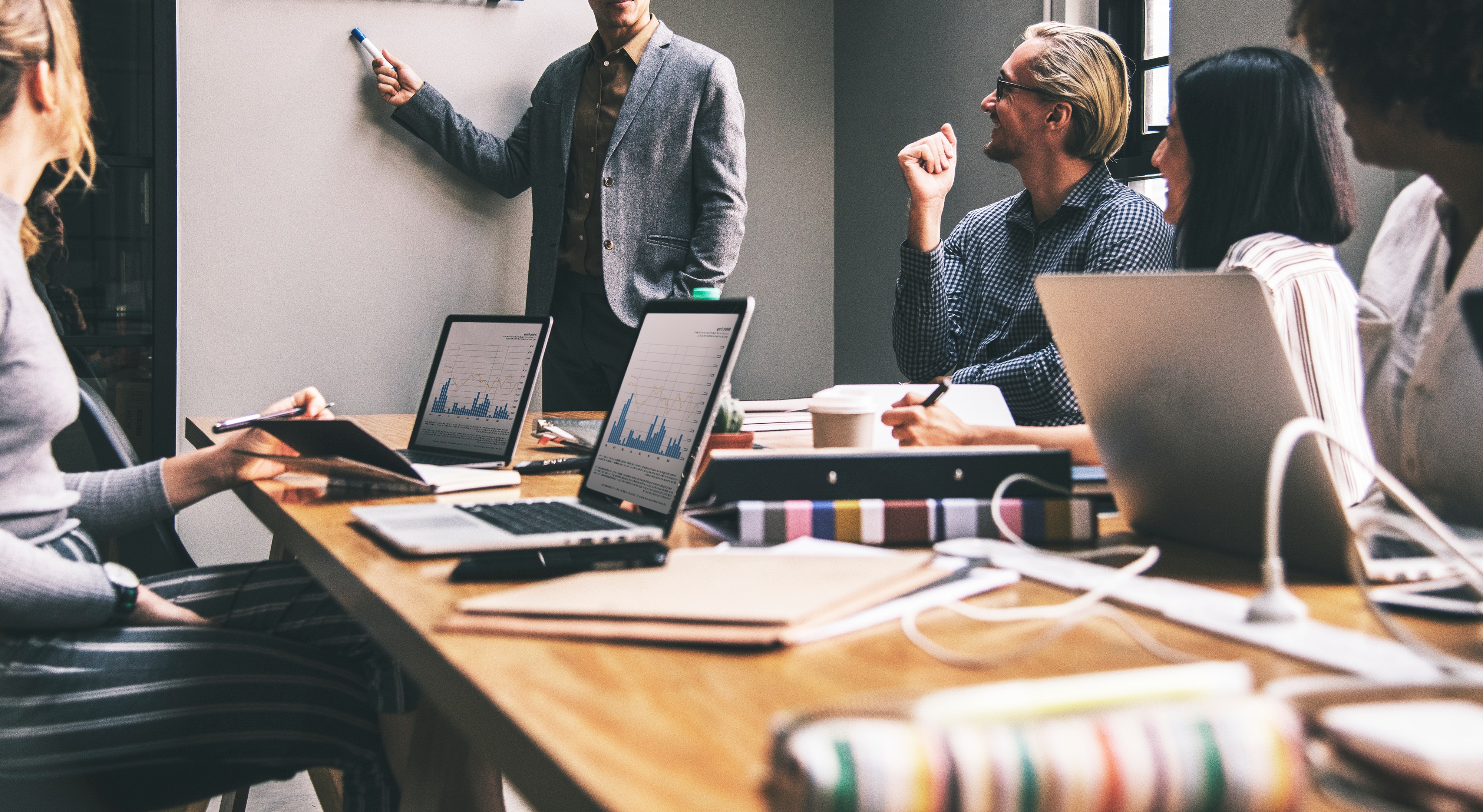 Man at whiteboard giving presentation to colleagues