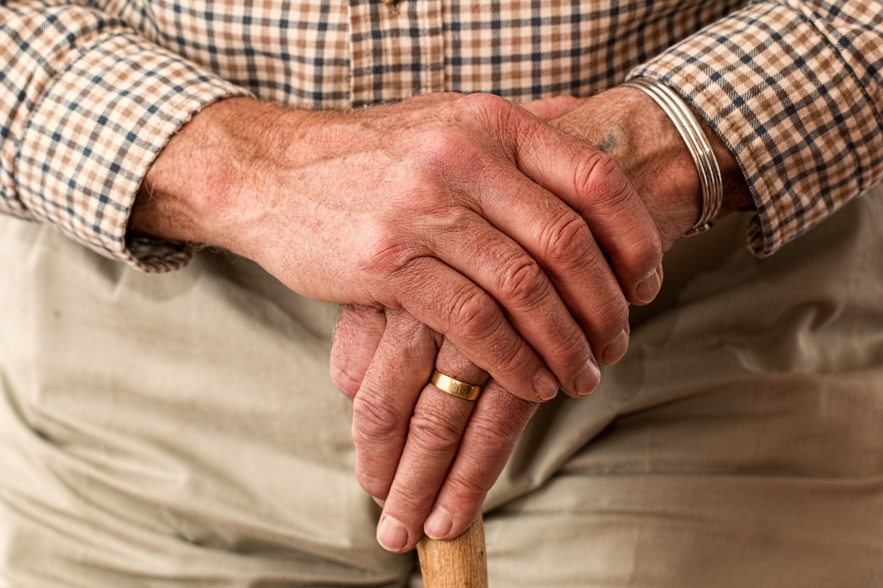 Close up of old man's hands on cane