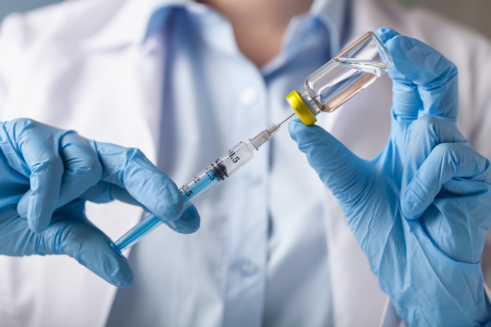 Doctor filling syringe with vaccine