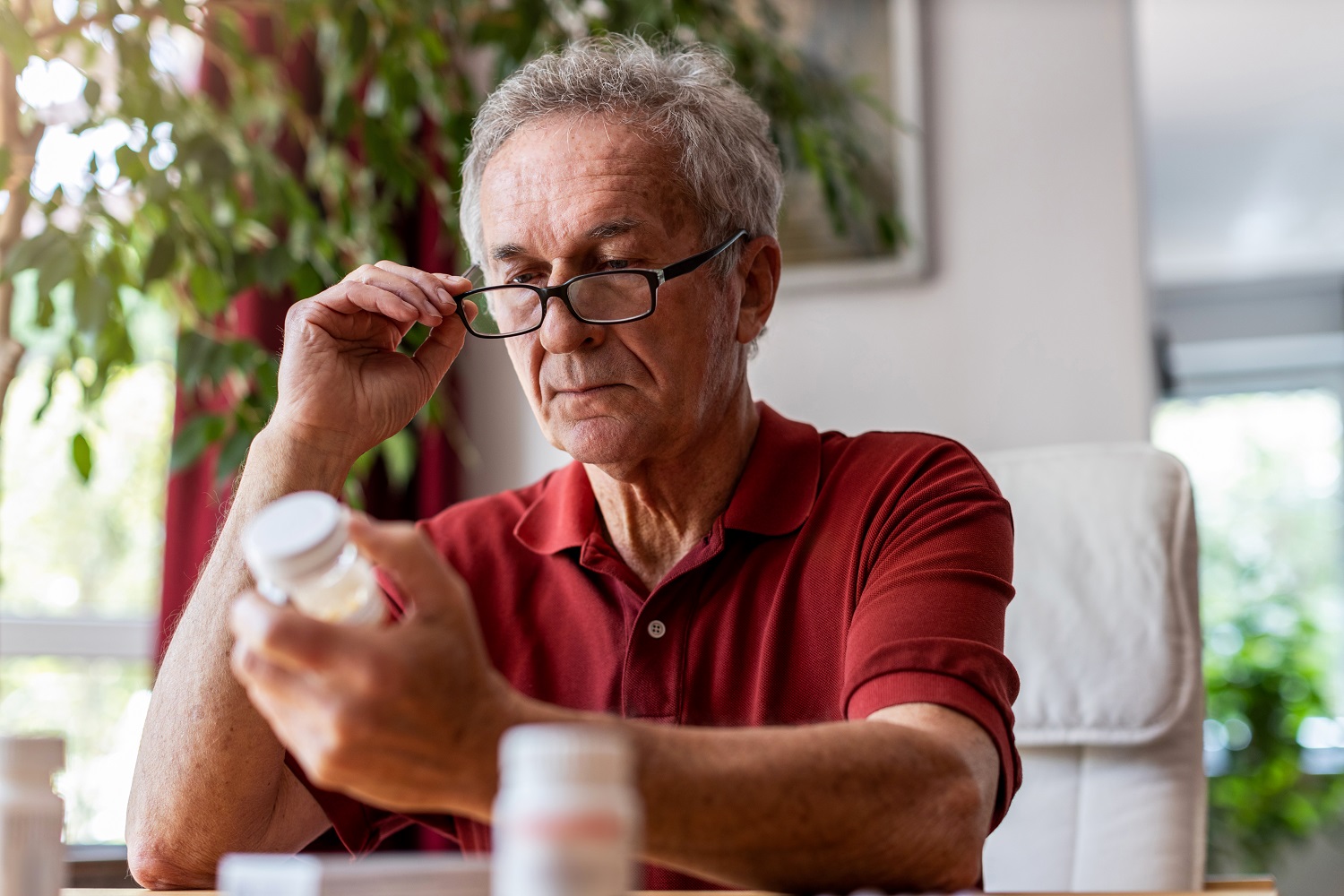 Older man looking at pill bottle